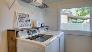 A laundry area with a Samsung washer and dryer, a sign that says "WASH DRY and FOLD", and a window with a view of the outside. - Adorable Coeur D'alene Home < 2 Mi to Lake! (Coeur d'Alene)