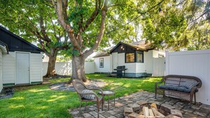 A backyard with a fire pit, wicker furniture, and a tree providing shade. - Adorable Coeur D'alene Home < 2 Mi to Lake! (Coeur d'Alene)