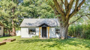 A single-story house with a dark front door, a small porch, and a well-maintained lawn. - Adorable Coeur D'alene Home < 2 Mi to Lake! (Coeur d'Alene)