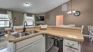 Una cocina moderna con una isla grande, pileta de acero inoxidable y lavavajillas.