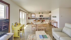A spacious living area with a sofa, a coffee table, and a dining table with chairs. - La Petit Maison - Lakefront Oshkosh Home! (Oshkosh)