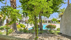 A pool area with a clear view of the pool, surrounded by trees and a well-maintained garden. - Chic Palm Springs Gem w/ Patio + Pool Access! (Palm Springs)