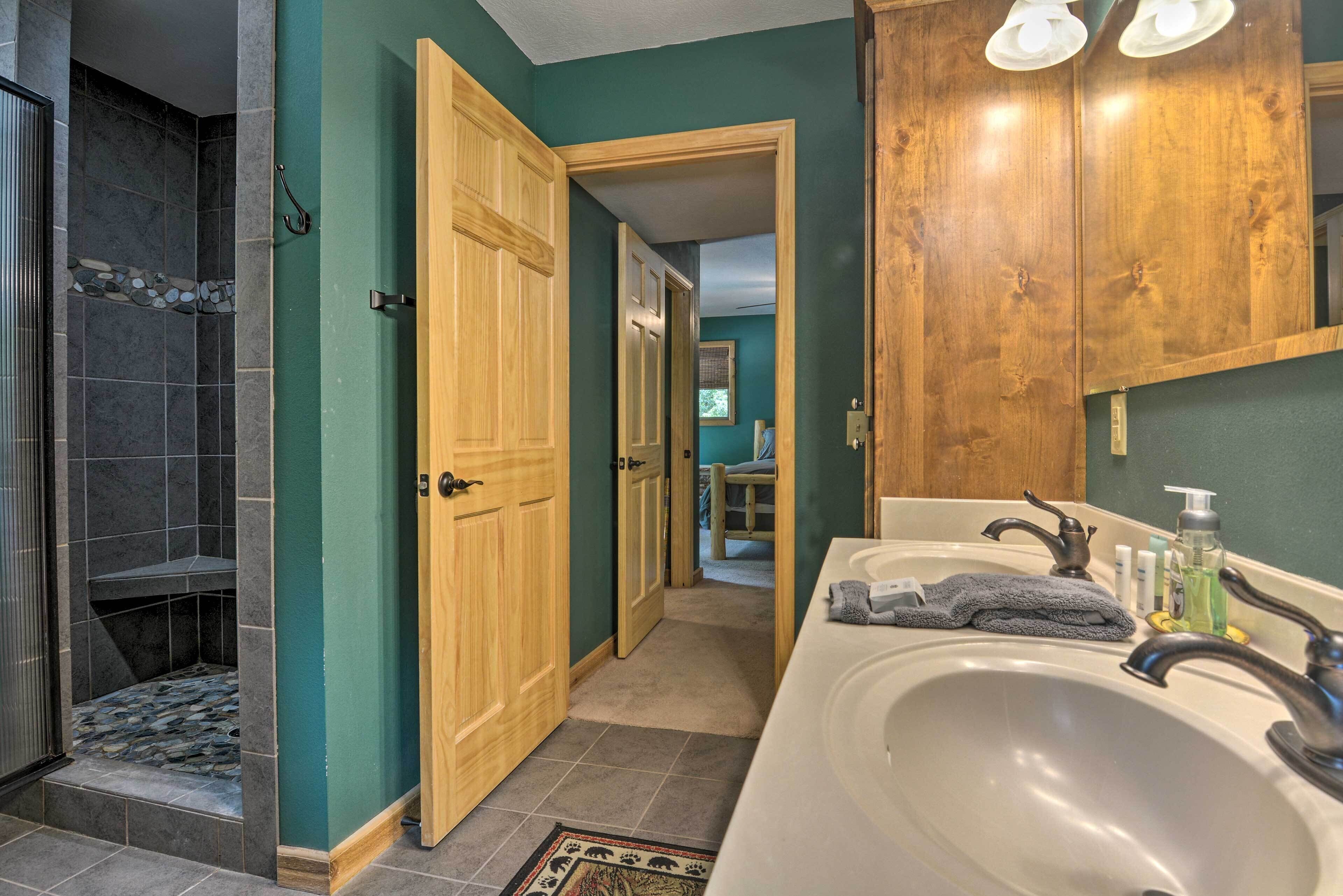 Une salle de bain avec une douche, un lavabo et des meubles en bois.