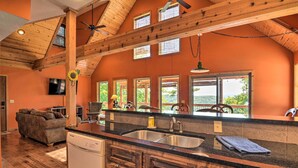 A kitchen with wooden beams, a large window, and a built-in dishwasher. - Spacious Log Cabin w/ Fire Pit & Game Room! (Eureka Springs)