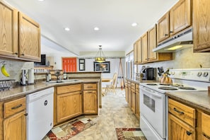 A kitchen with wooden cabinets, a dishwasher, a stove, and a refrigerator. - Fishing Haven: Family Home on Indian Lake (Rhinelander)