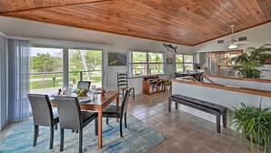 Una cocina amplia con techo de madera, ventanas grandes y vistas al exterior.