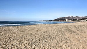 A wide sandy beach with a clear blue sky and ocean. There are buildings and a pier in the background. - Walk to Ventura Beach: Comfy Home w/ Ocean Views (Ventura)