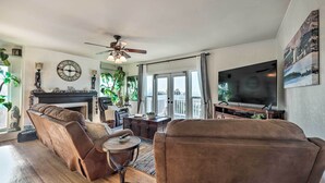 A living room with a fireplace, a television, and a large window. - Walk to Ventura Beach: Comfy Home w/ Ocean Views (Ventura)