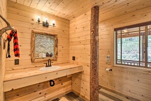 A wooden cabin bathroom with a sink, mirror, and window. - Jefferson Cabin w/ Fire Pit & Sauna Near Hiking! (Jefferson)