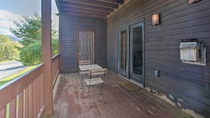 A covered porch with a wooden deck, a door, and a sliding glass door. - Hunter Mountain Ski Retreat - Steps to Lift! (Hunter)