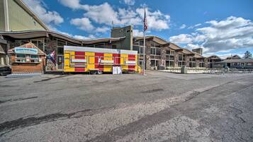 A food truck with a red and yellow design parked in front of a building with a flag.