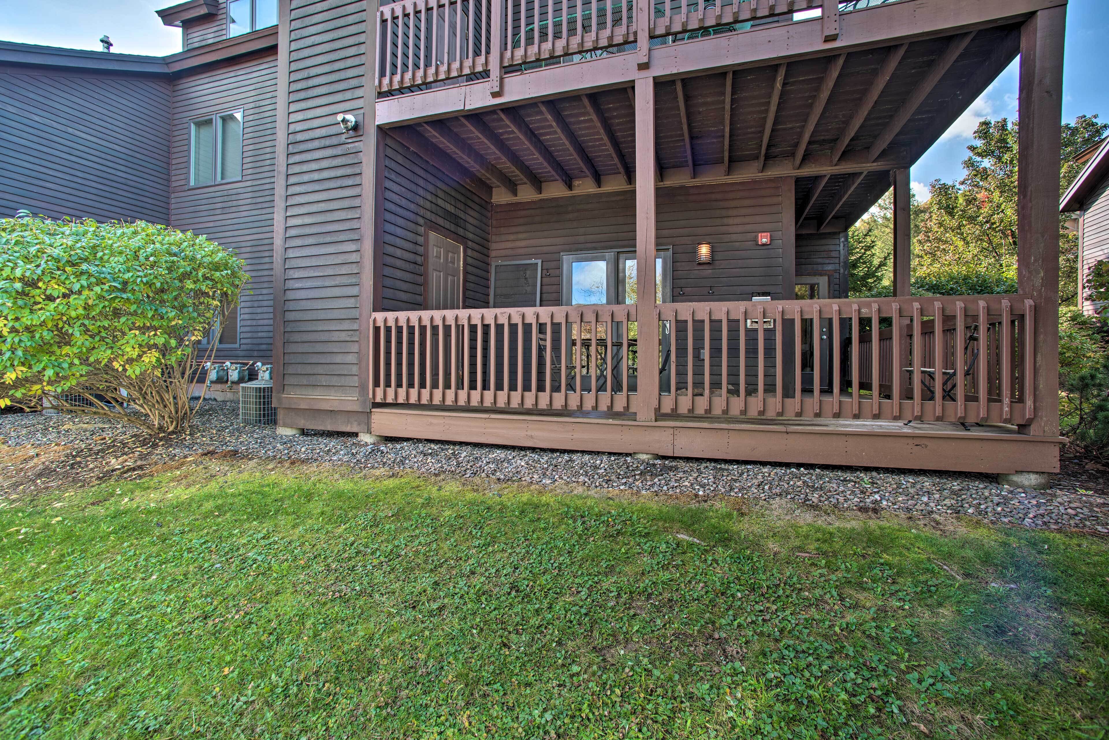 A two-story building with a wooden deck and a covered patio area.