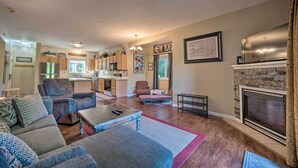 A spacious living room with a fireplace, a kitchen in the background, and a dining area. - Hunter Mountain Ski Retreat - Steps to Lift! (Hunter)