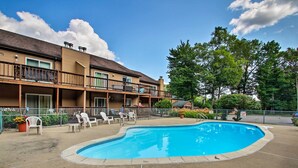 Een hotel met een zwembad, terras en een omheind terras.