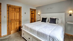 Een slaapkamer met een groot bed, houten deuren en een bord aan de muur.