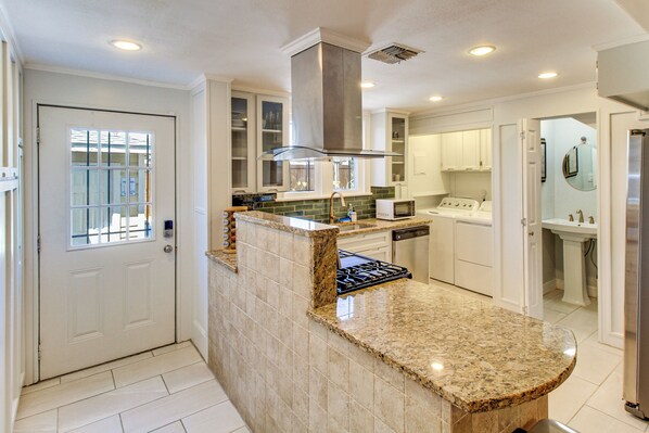 A modern kitchen with granite countertops, stainless steel appliances, and a built-in oven.