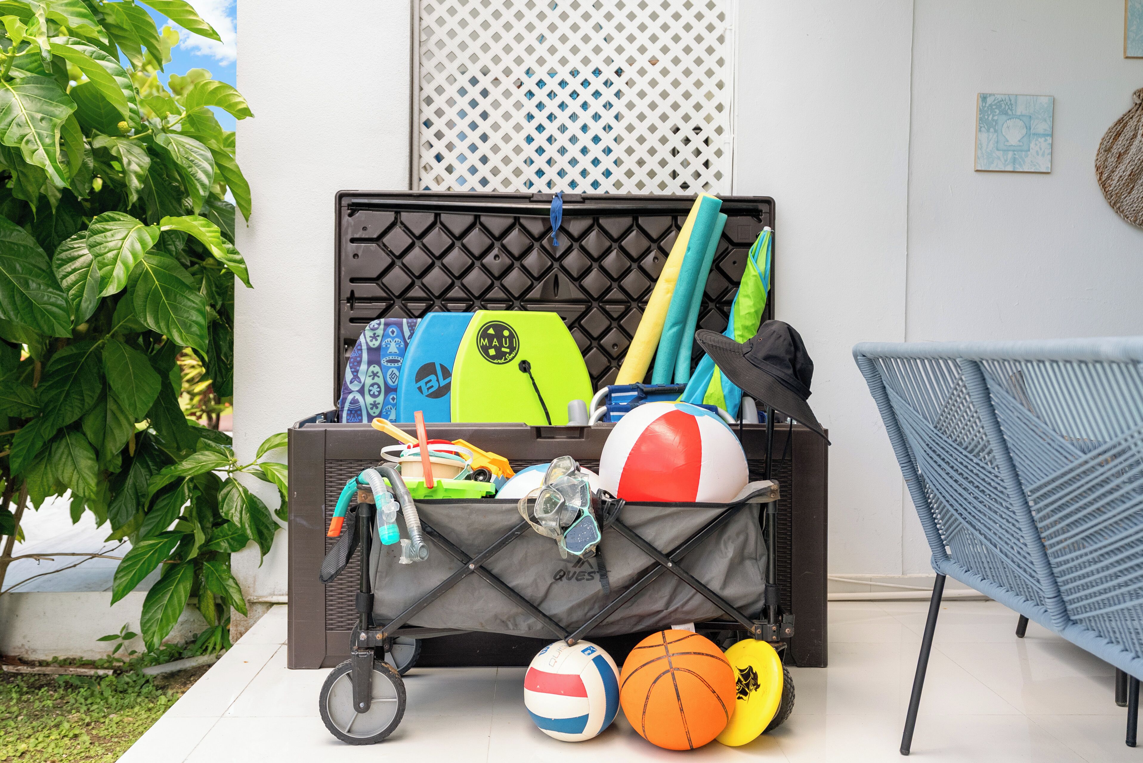 A storage unit with various sports equipment, including a bicycle, a beach ball, and a surfboard.