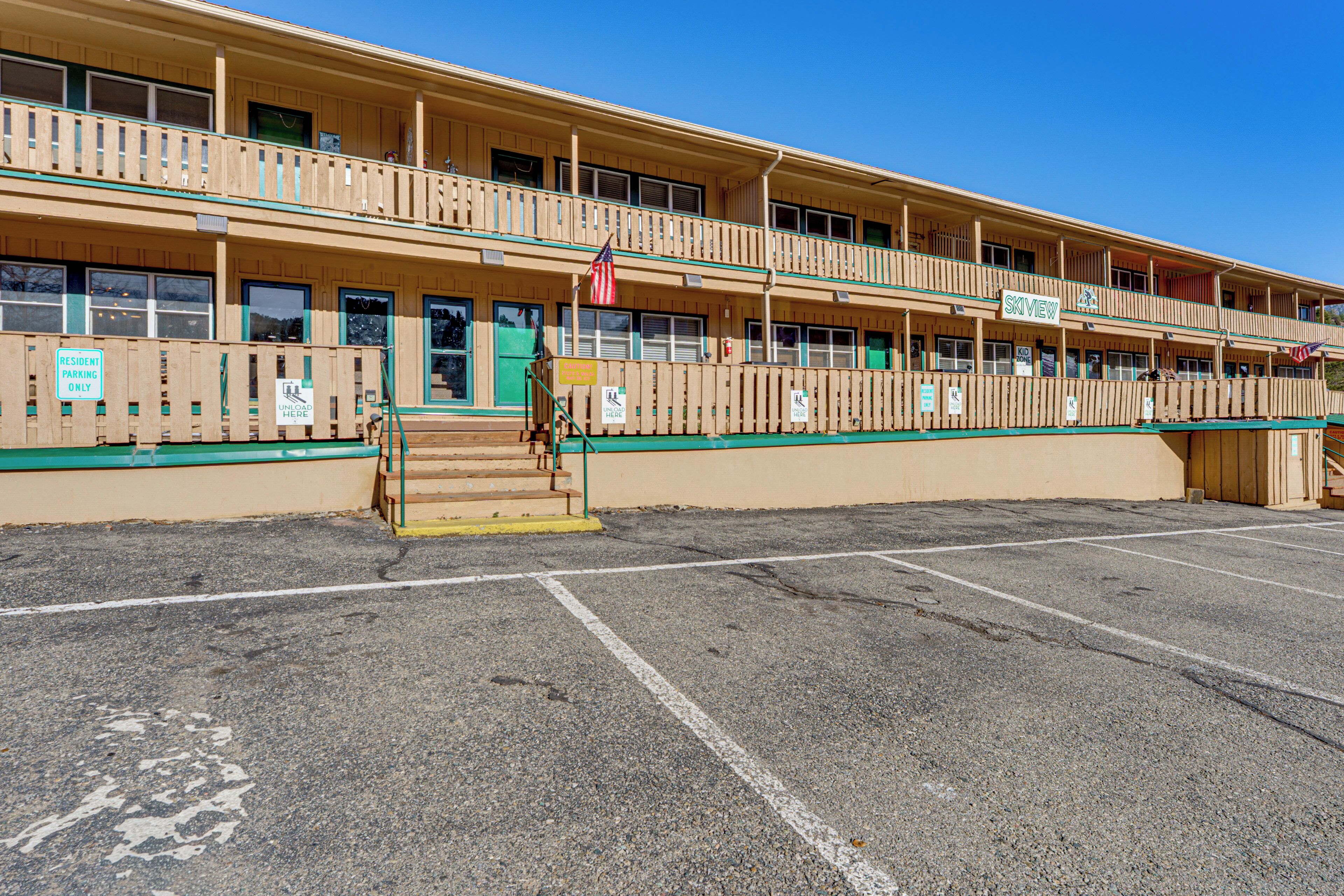 Un motel à deux étages doté d’un balcon à l’étage supérieur, d’un parking à l’avant et d’un panneau indiquant que le stationnement est réservé aux résidents.