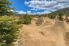 A dirt biking track with ramps and trees. - Walk to Frisco Main St: Townhome Steps to Trail! (Frisco)