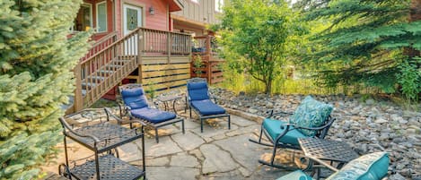A patio with stone flooring, outdoor furniture, and a staircase leading to a building.
