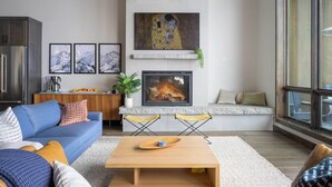 Un salon moderne avec un canapé bleu, une table basse en bois et une cheminée.