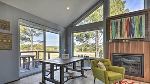 A modern interior with a dining table, a green armchair, and a fireplace. - Lake Pagosa Home w/ Hot Tub & Mtn/lake Views! (Pagosa Springs)