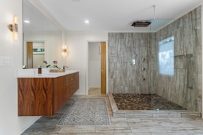 A modern bathroom with a vanity, shower, and a large mirror. - Live Oaks & Marina Views! Ocean Springs Home (Ocean Springs)