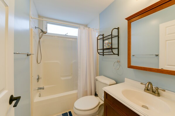 A bathroom with a bathtub, toilet, and sink.