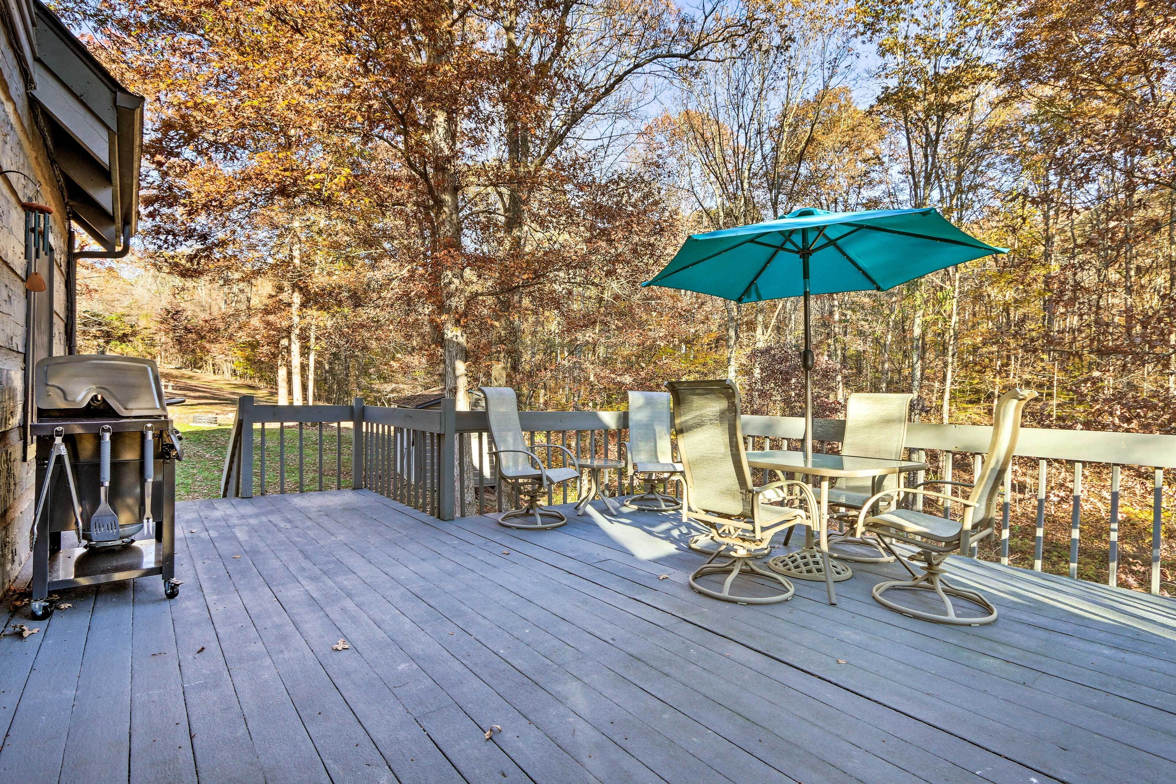 A wooden deck with outdoor furniture and a grill.