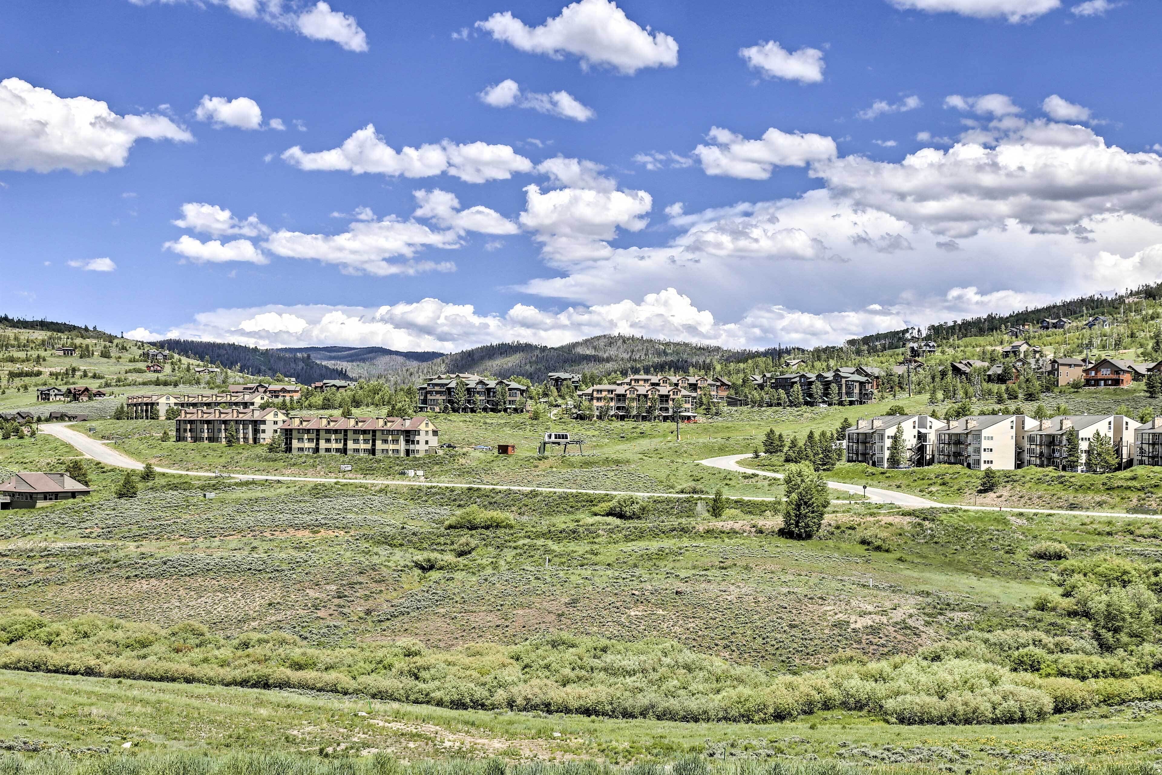 A residential area with multiple apartment buildings, roads, and green fields.