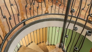Una escalera de caracol con escalones de madera y barandillas de metal.