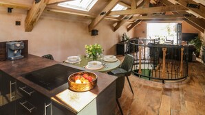Un acogedor loft con comedor, cocina equipada con estufa incorporada y un amplio ventanal que proporciona luz natural.