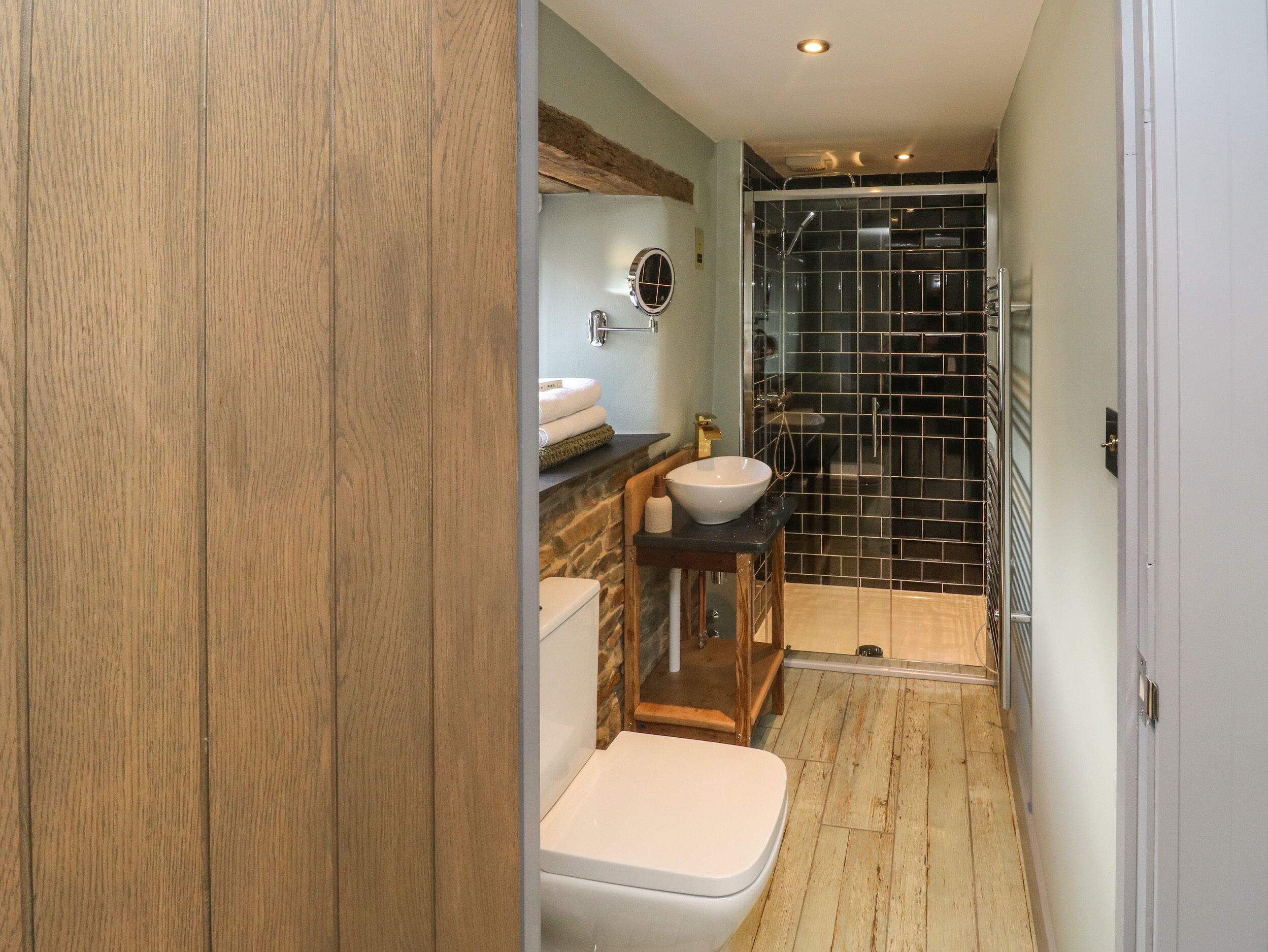 A compact bathroom with a toilet, sink, and shower area.