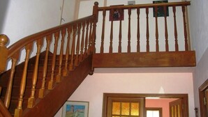 Un escalier en bois, doté d’une main courante, mène à l’étage supérieur.