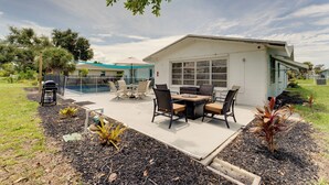 Une maison moderne dotée d’un patio, de mobilier d’extérieur et d’une piscine.