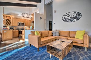 A modern living room with a sectional sofa, a coffee table, and a kitchen in the background. - Epic Mammoth Lakes Getaway w/ Shared Pool, Hot Tub (Mammoth Lakes)