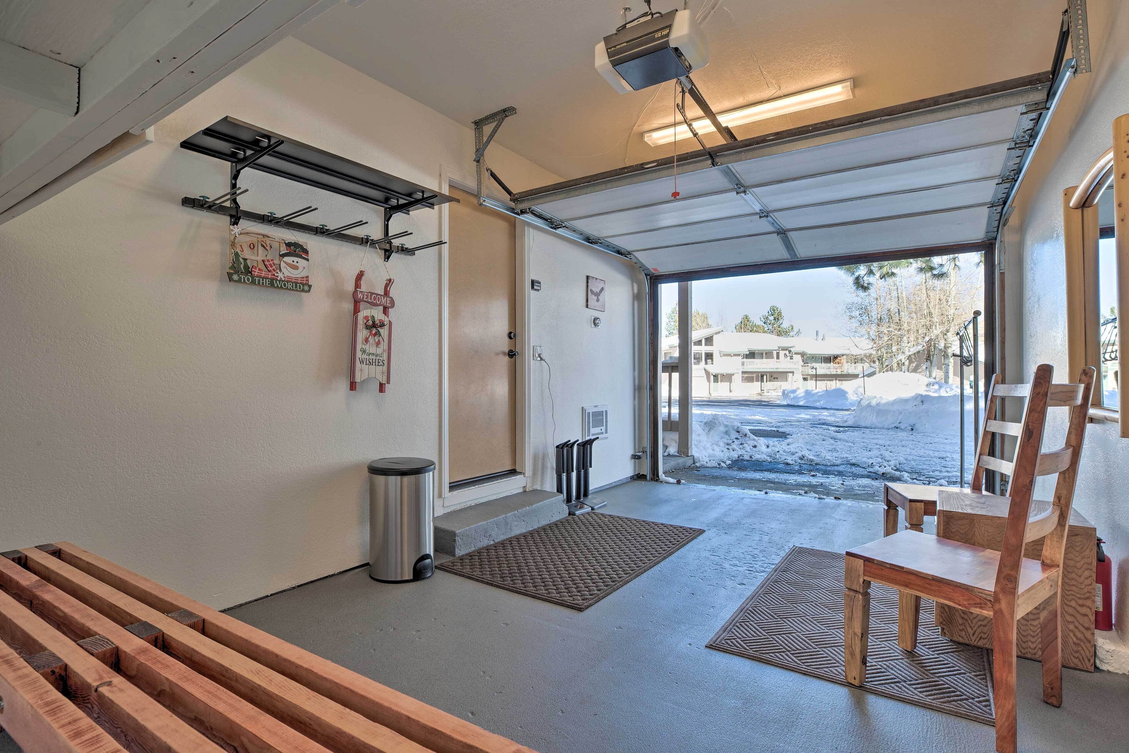 A garage with a wooden bench, a metal shelf, a welcome sign, and a view of a snowy landscape.