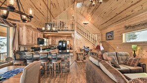 A spacious wooden cabin interior with a dining area, bar, and seating. - Rio Grande National Forest Cabin: Views & Hot Tub (Del Norte)