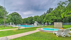 Ein Poolbereich mit mehreren Pools, umgeben von grünem Rasen und Bäumen.