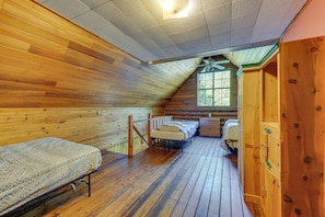 A log cabin bedroom with two beds, a desk, and a window. - Historic Century-old Cabin in Downtown Hope (Hope)