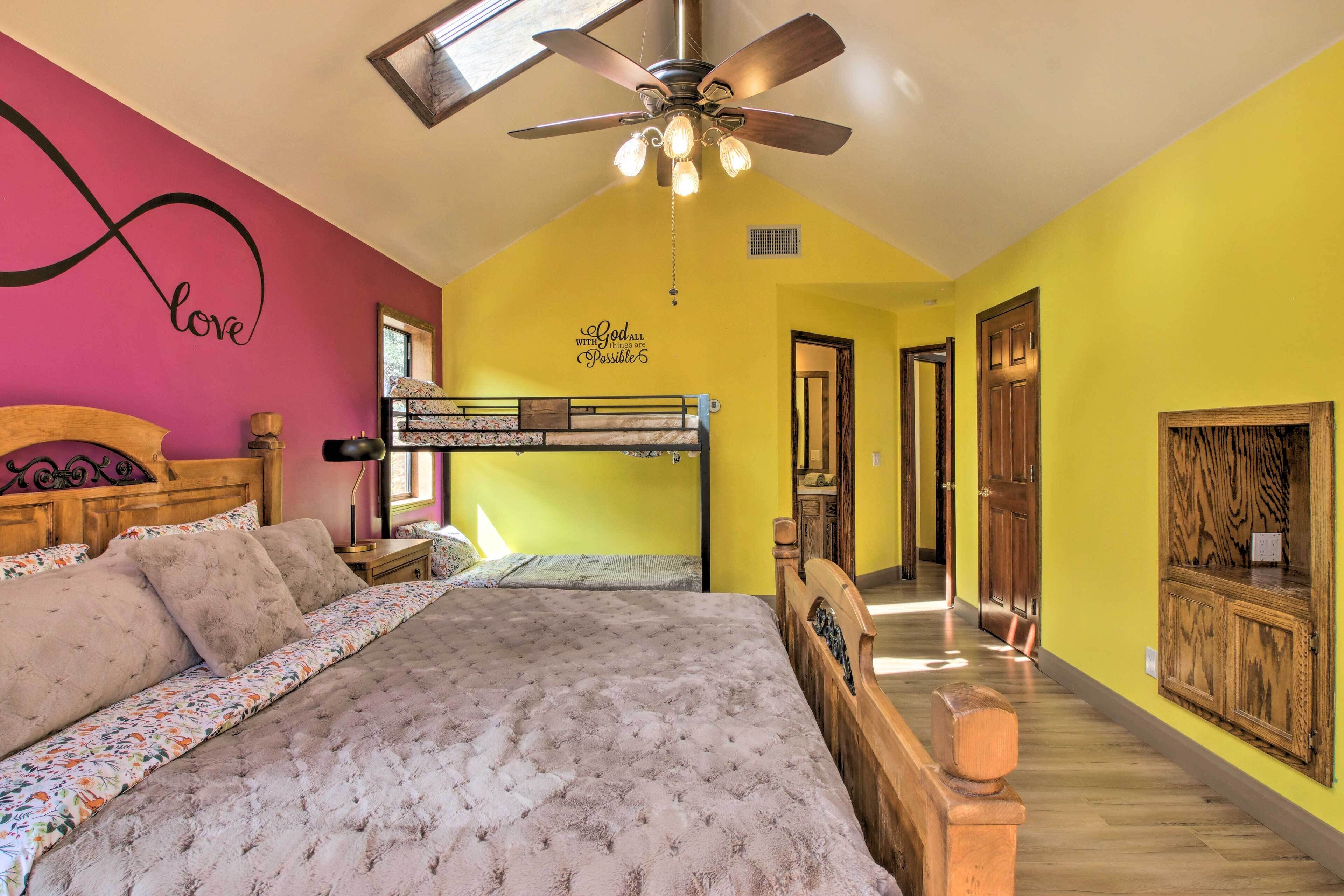 Une chambre avec un lit superposé, un ventilateur de plafond et un autocollant mural inspirant.