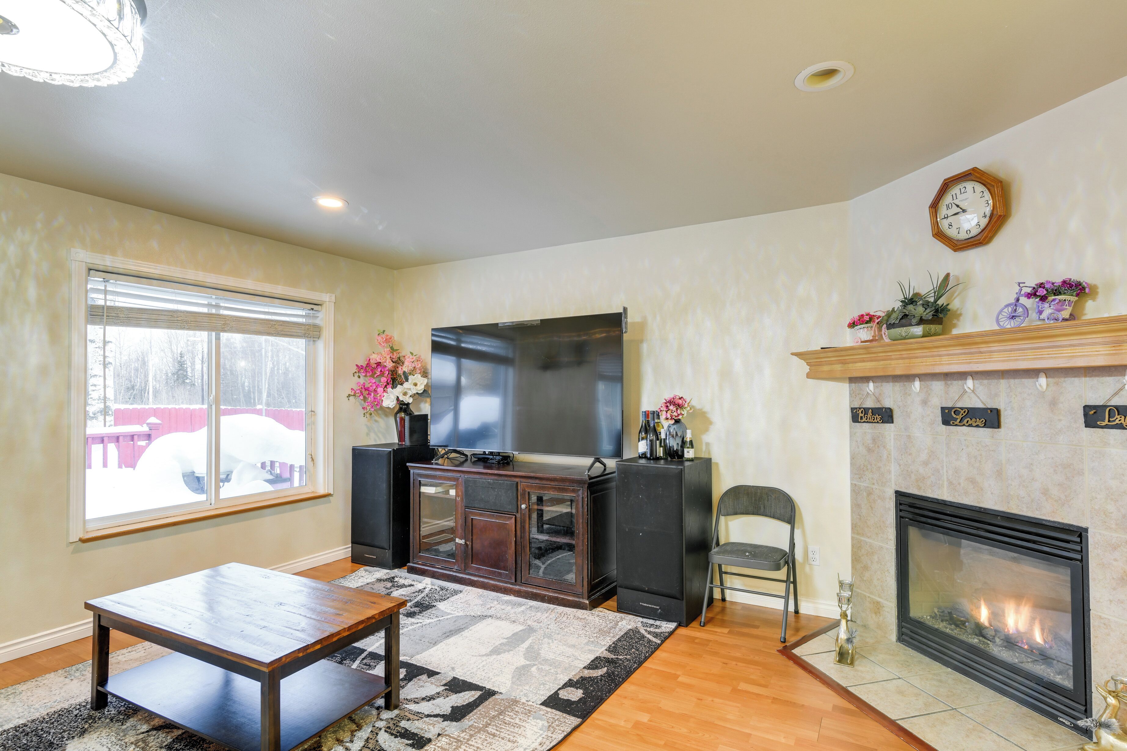 A living room with a fireplace, a flat-screen TV, and a wooden coffee table.