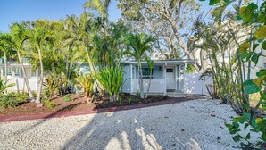 A house with a gravel driveway, surrounded by palm trees and other vegetation. - Indian Rocks Beach Retreat, Walk to Gulf & Beaches (Indian Rocks Beach)