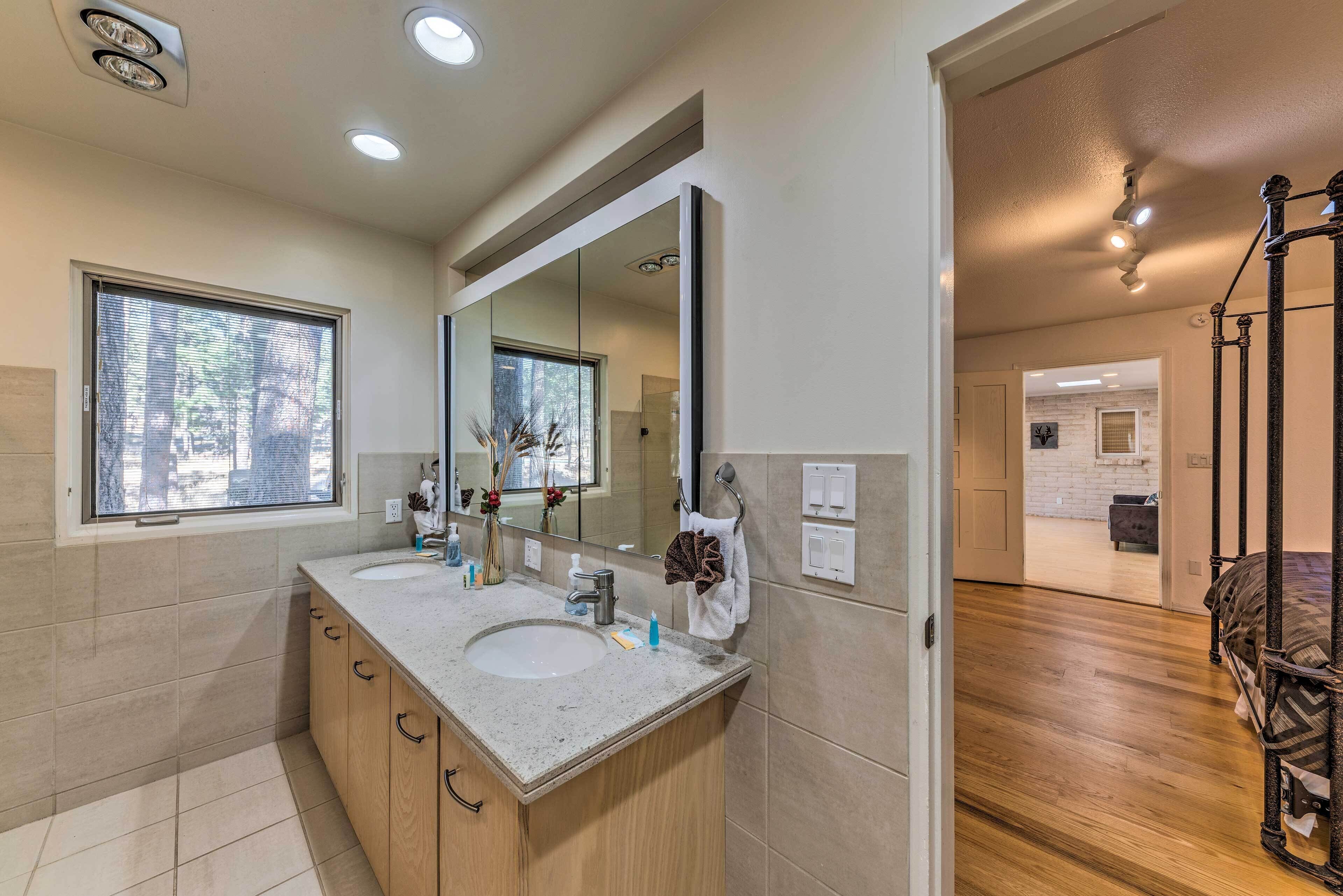 Une salle de bain moderne avec deux lavabos, un grand miroir et un meuble-lavabo en bois.