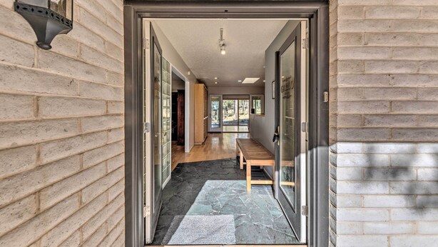 Un couloir avec un banc, une porte portant l’inscription « 104 », et un sol imitant le motif de la pierre.