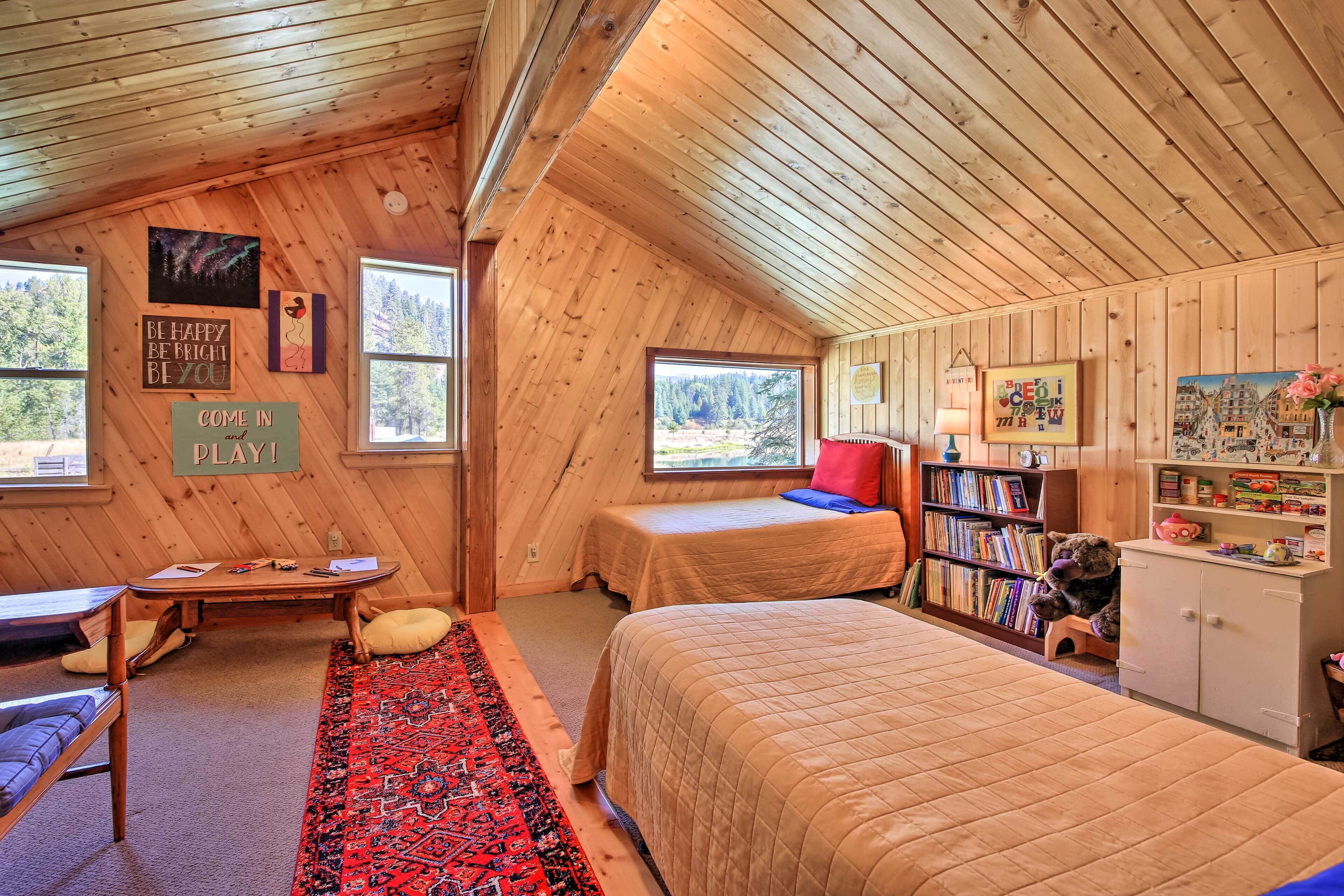 A cozy cabin with two beds, a desk, and a bookshelf.