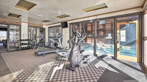 Een fitnessruimte met loopbanden, elliptische trainers en een gewichtrek.
