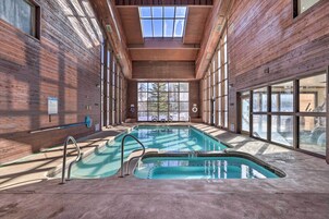 Una piscina interior con paredes de madera y ventanas amplias.