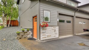 A residential house with a stone facade, a garage, and a gravel driveway.