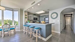 A modern kitchen with a bar area, large windows, and a view of the outdoors. - ~ 2 Mi to Disney & Universal: Orlando Resort Condo (Orlando)